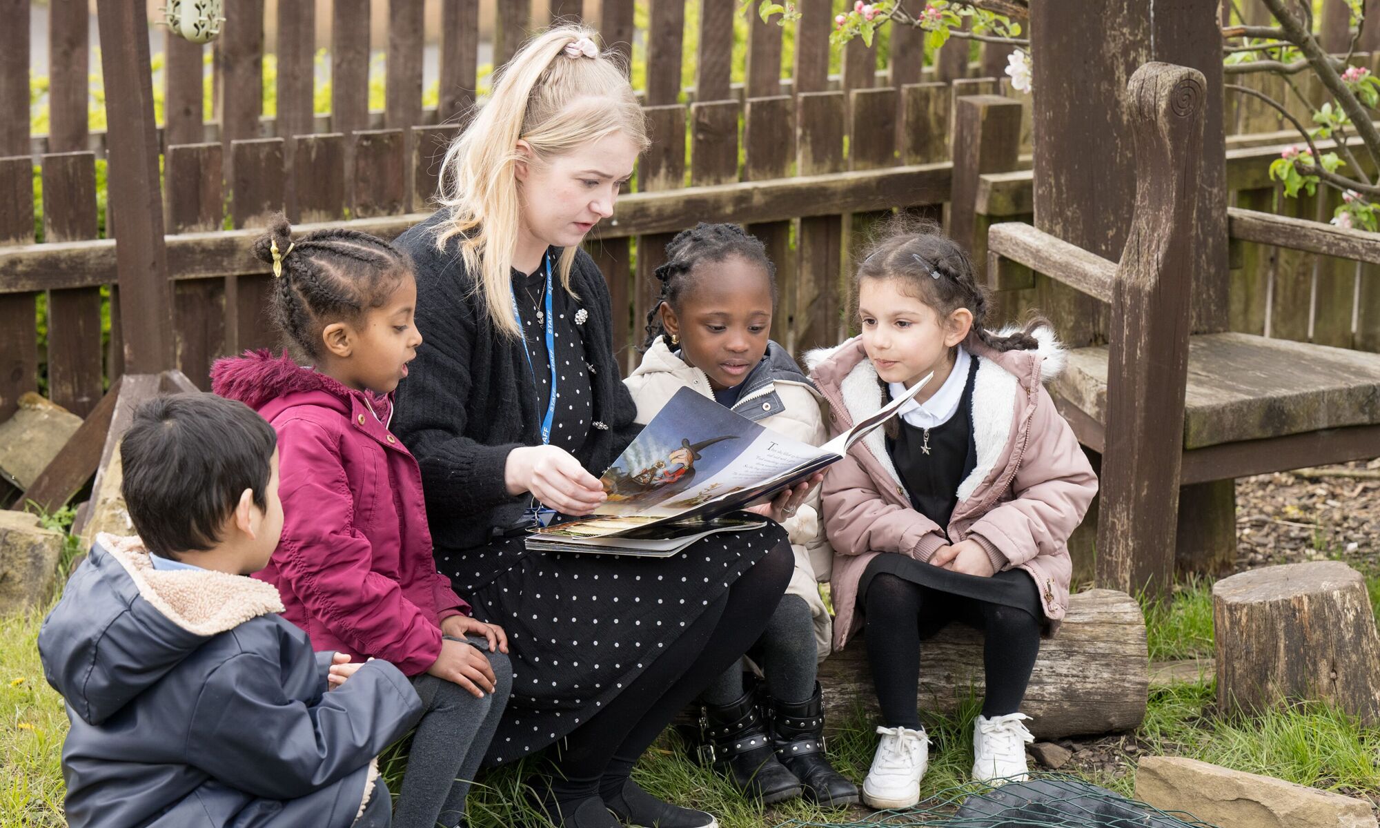 Byron Primary School - pupils with teacher reading outside